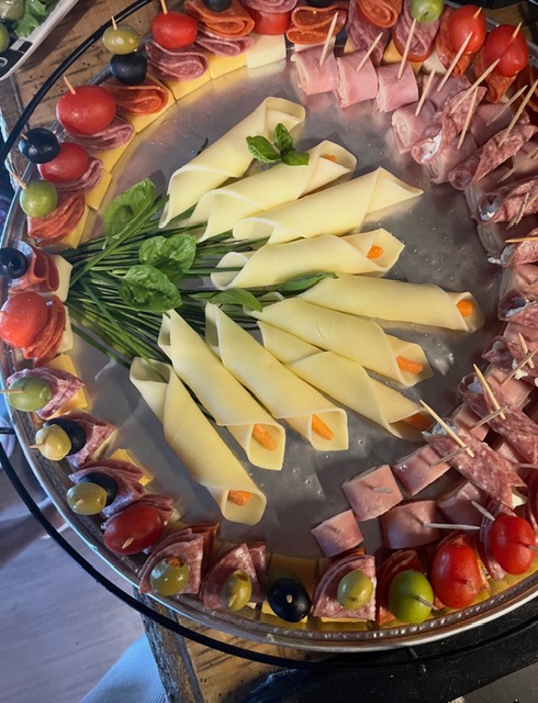 An artfully arranged charcuterie board with cheeses, cured meats, and olives
